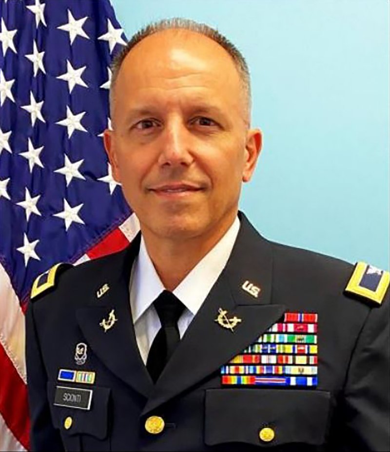 Judge Michael Scionti in U.S. Army dress uniform, standing in front of an American flag